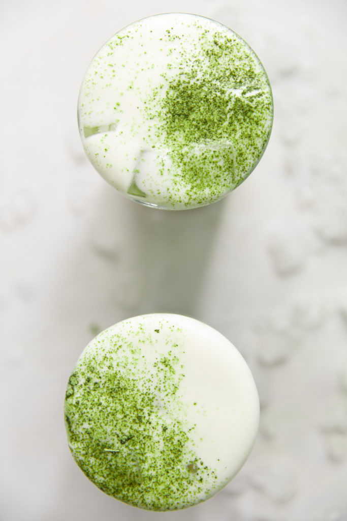 Image of two vanilla iced matcha lattes with matcha powder sprinkled on top
