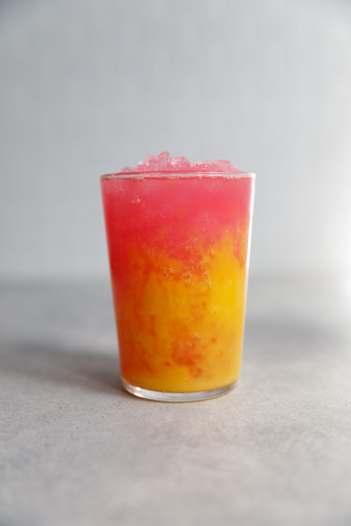 Picture of mango dragon fruit cooler on a grey backdrop