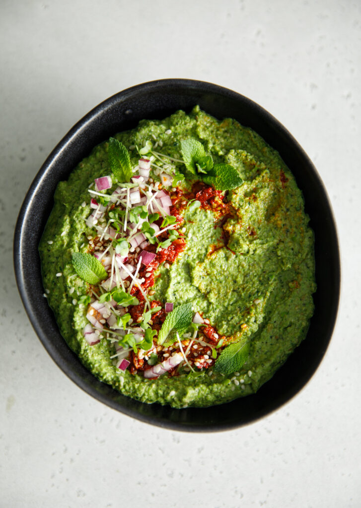 Green pea, lentil and mint dip in a black bowl