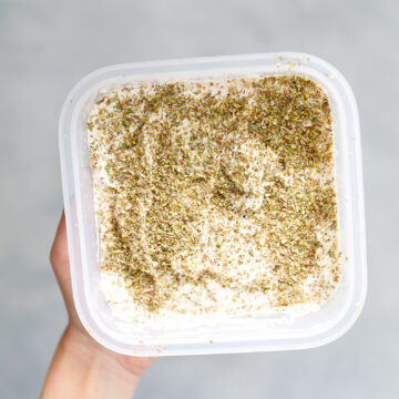tofu feta covered in dried oregano in a tupper