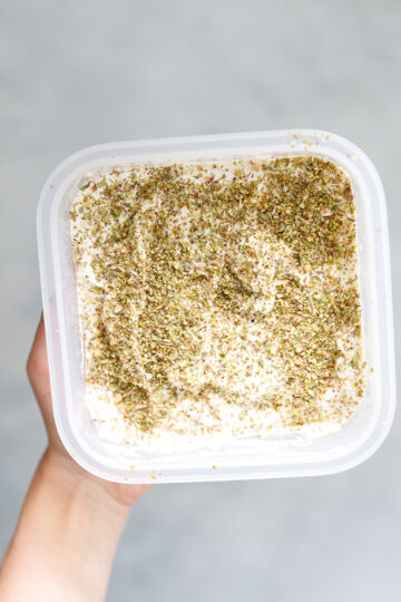 tofu feta covered in dried oregano in a tupper