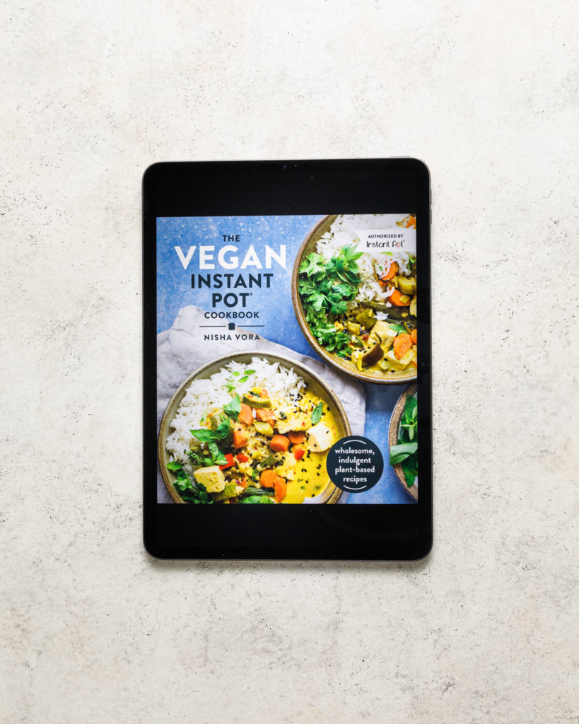 The Vegan instant pot kindle cookbook on a beige textured backdrop
