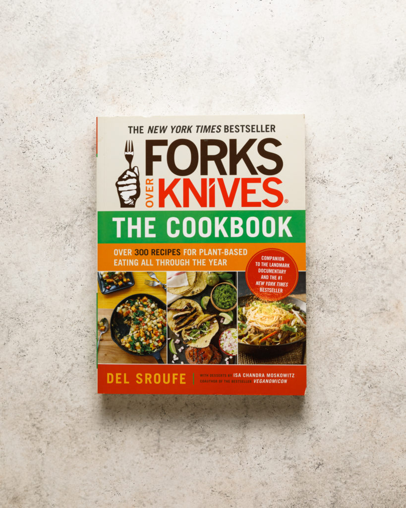 Forks over Knives cookbook on a beige textured backdrop