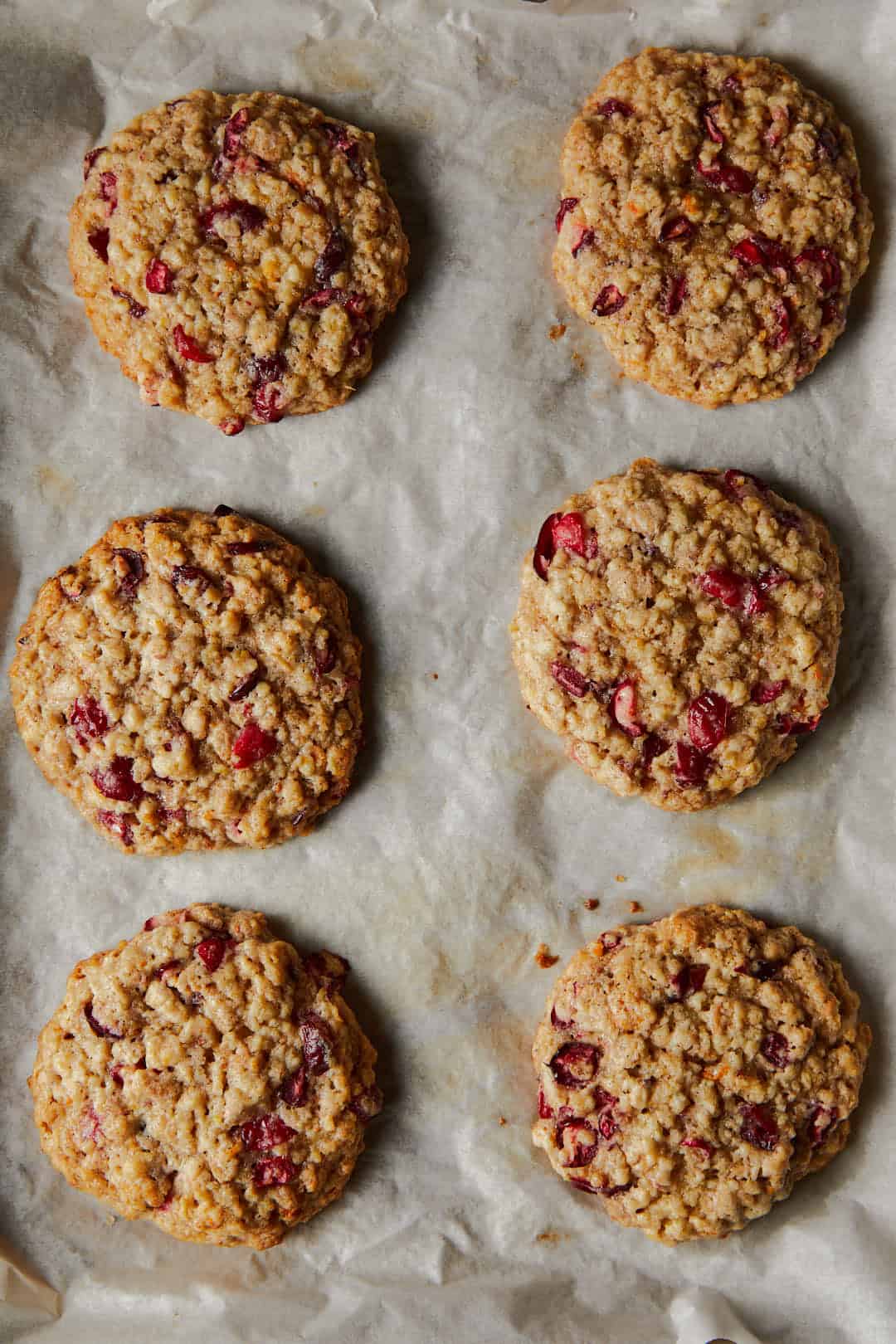 Cranberry Cardamom Oat cookies on a lined baking sheet