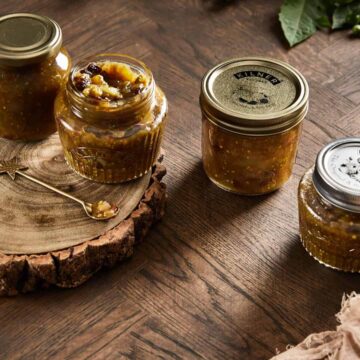 image of four green tomato chutney jars on a wooden backdrop