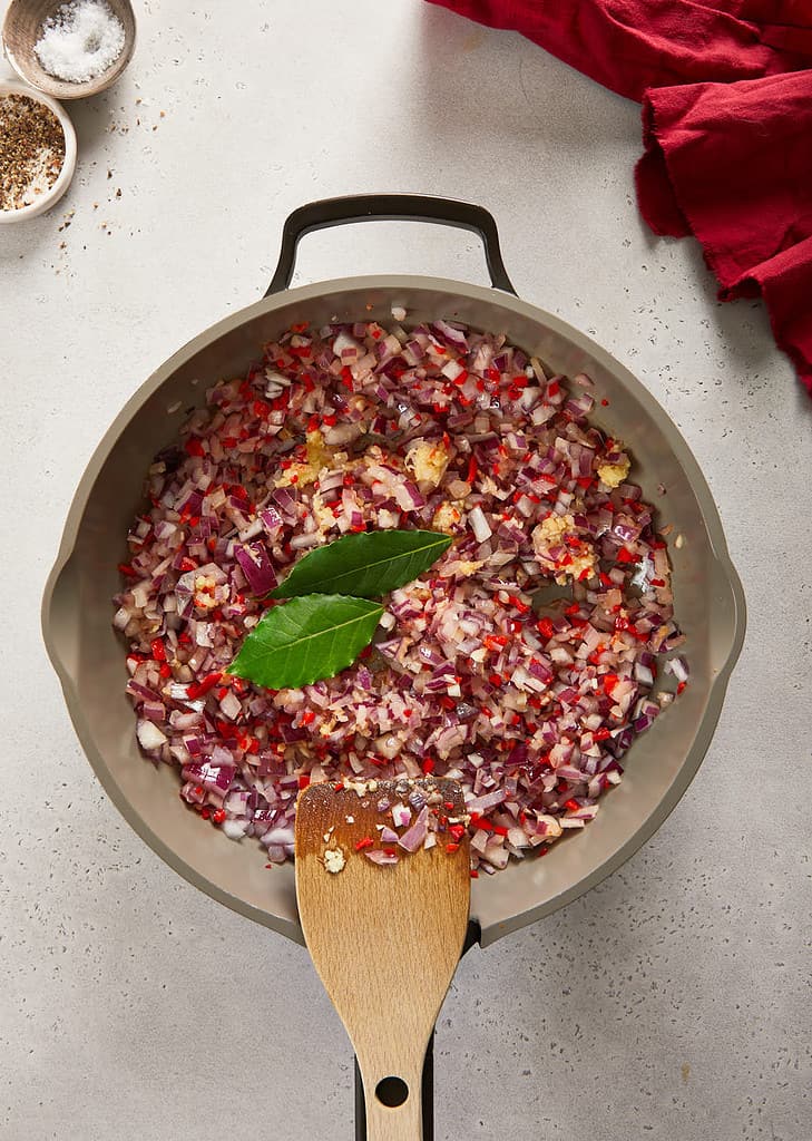 cranberry sweet chilli jam bay leaves being added into the  pan