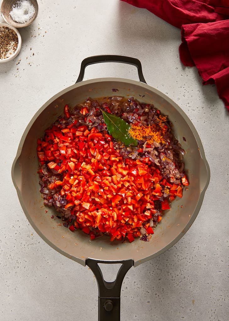 cranberry sweet chilli jam diced red pepper being added into the  pan