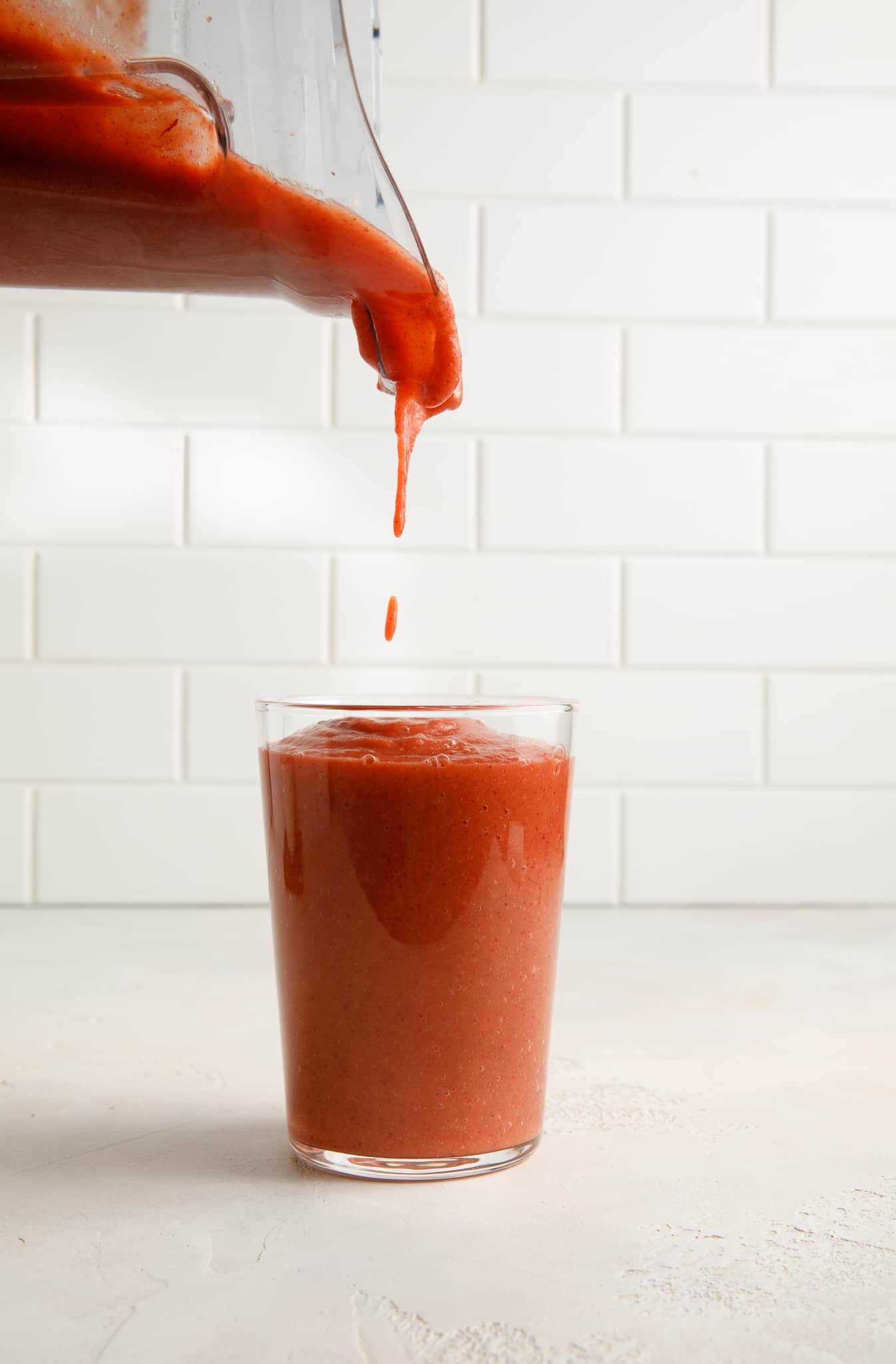 Sweet Potato & Cranberry Superfood Smoothie being poured into a water glass