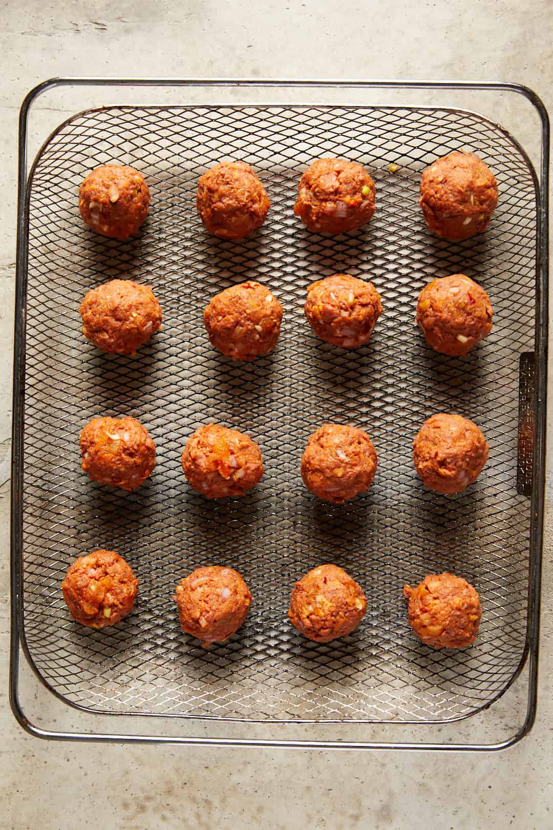 Image of the raw Spicy harissa vegan meatballs on a air fryer tray