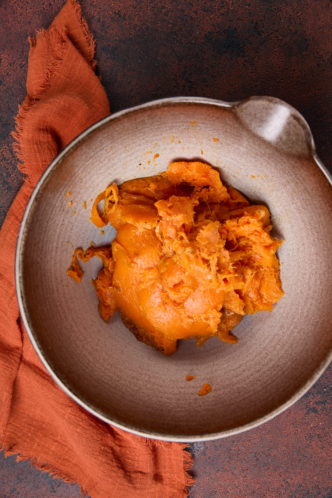 sweet potato flesh in a bowl after being scooped out the skins