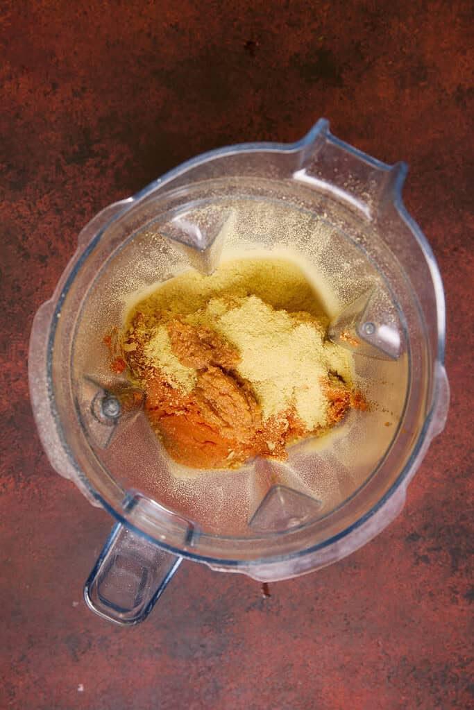 pumpkin puree, miso paste, nutritional yeast, salt and pepper in a blender jug 