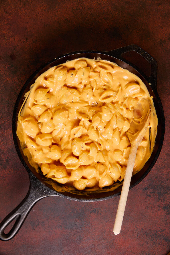 pasta fully coated in the pumpkin pasta sauce in a cast iron pan