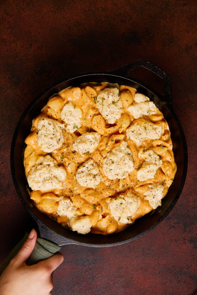 mozzarella being added to the top of the pumpkin mac and cheese 