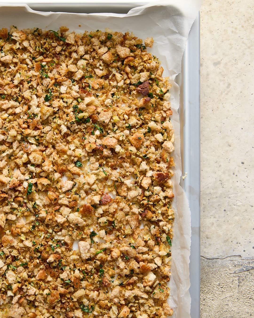 Lemon parsley garlic breadcrumbs drying on a silver baking sheet