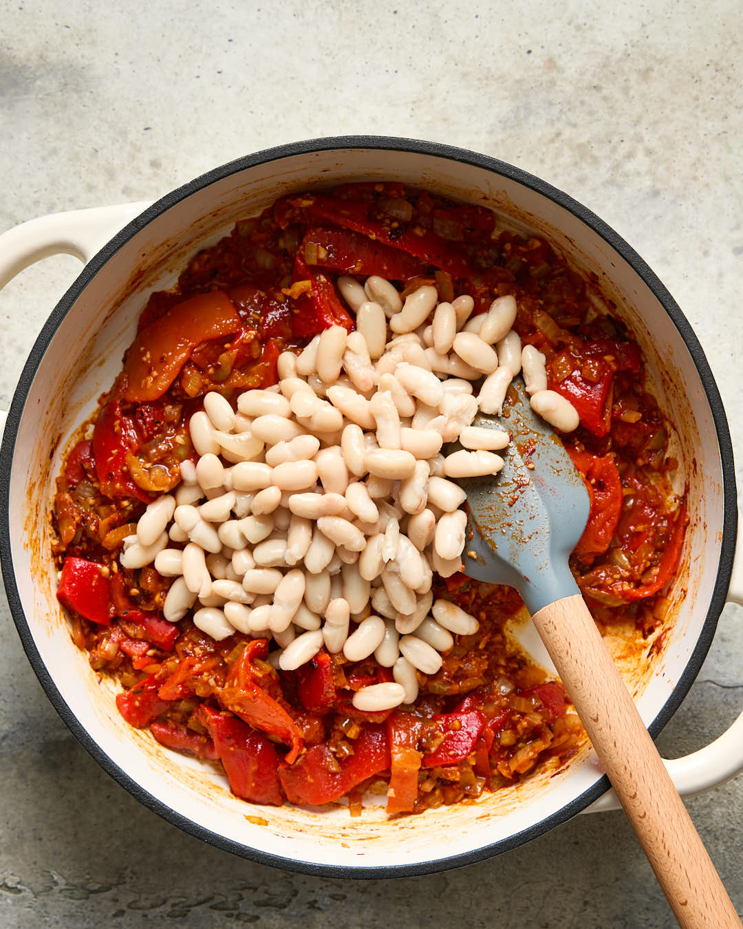 Beans being added to sauce