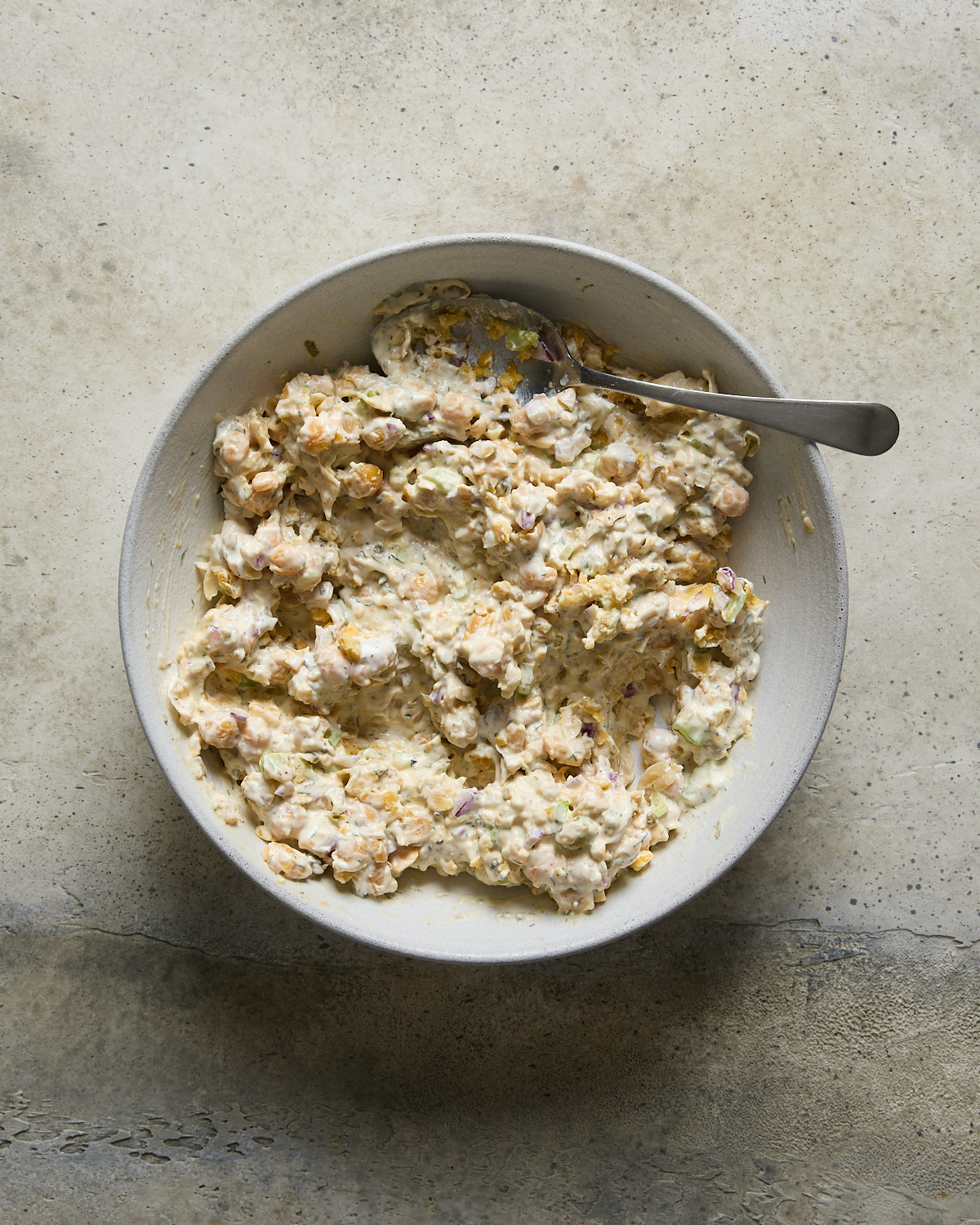 A bowl filled with the chickpea tuna mixture waiting for nori to be added, all in a light bowl.