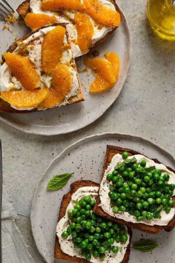 Two plates of toast—one with sweet ricotta and orange, the other with savoury ricotta and fresh green peas, mint, and cracked pepper.